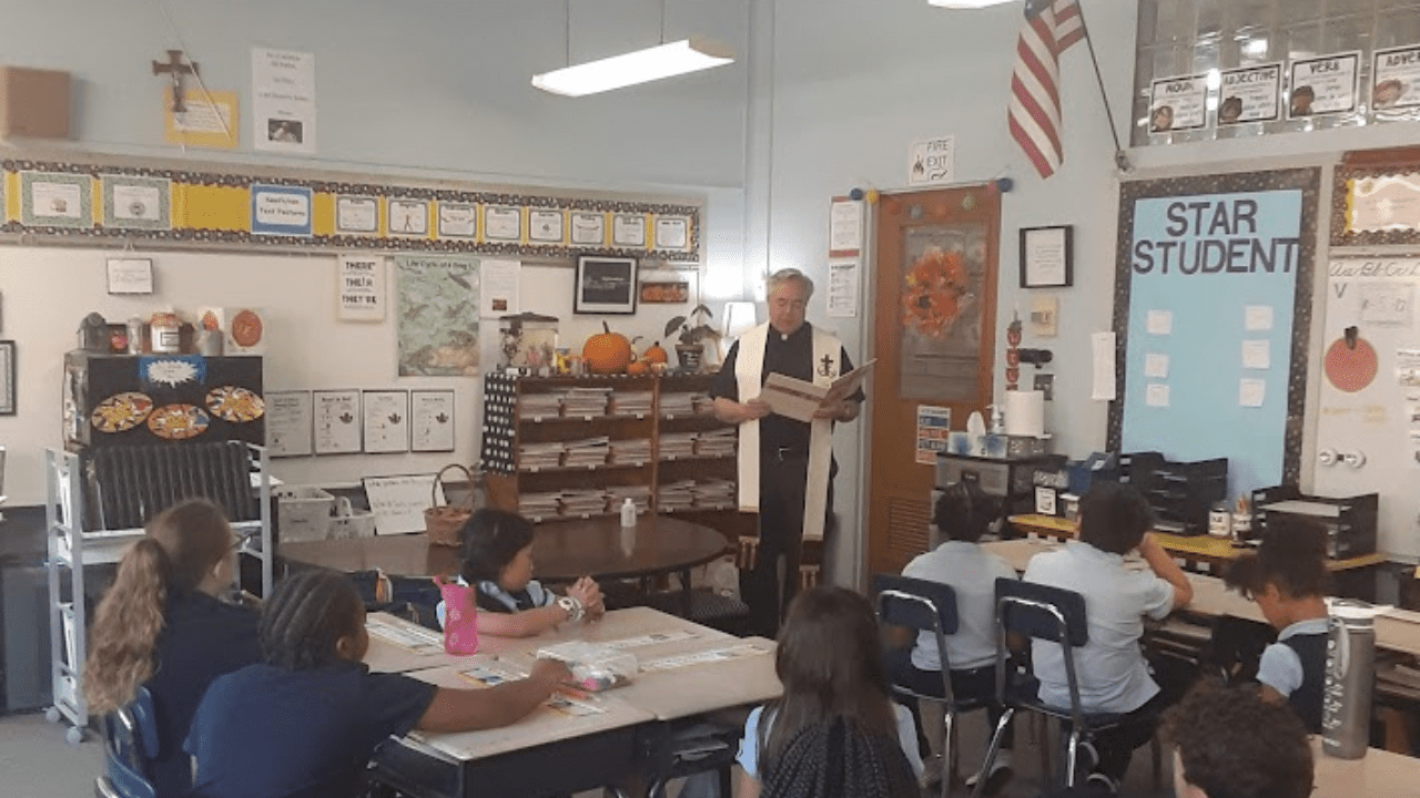 Father Jim Fenstermaker blessing a classroom at Holy Cross School in South Bend, IN.